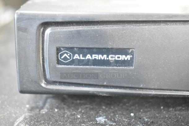 Alarmcom unit with visible logo in used condition. Part of a lot including a cash drawer, doubling your bid value.
