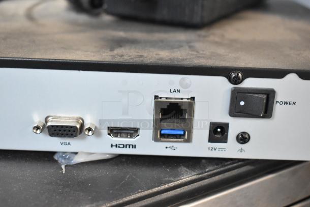 Back of Alarmcom unit showing VGA, HDMI, LAN, and power ports with a black switch labeled "POWER."