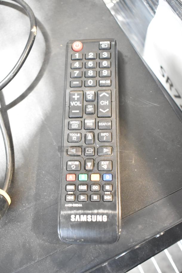 Samsung remote control, black, model AA59-0065A, with various function buttons visible on a dark surface.