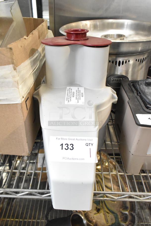 Brand new gray poly continuous feed head attachment for food processor, minor dents, auction tag "133" visible.