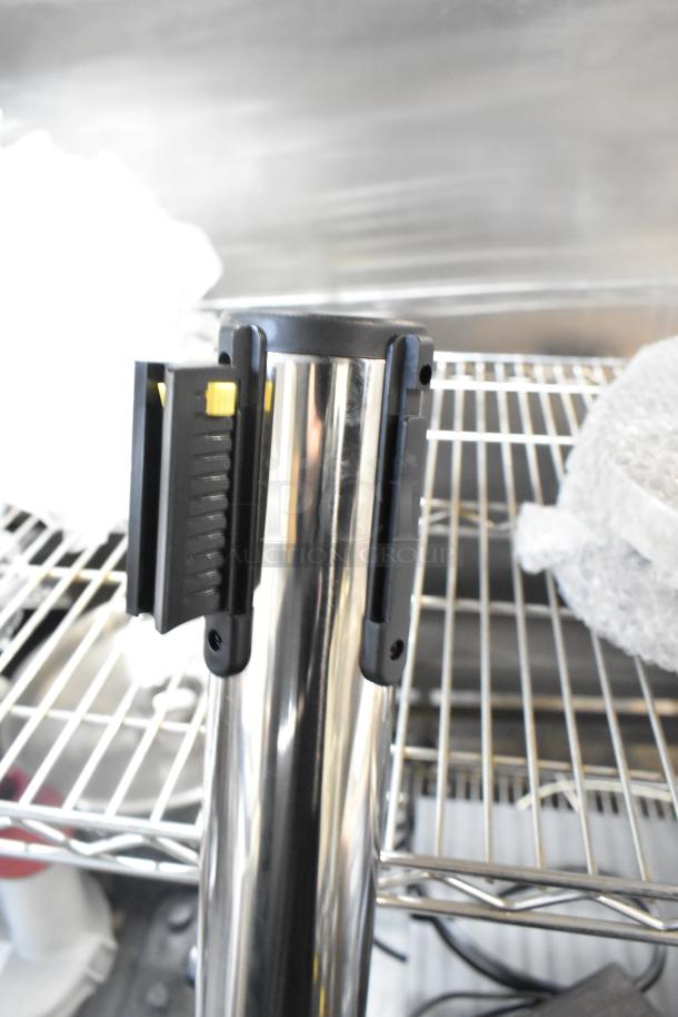 Brand new Lancaster Table & Seating stanchion, scratch and dent condition, chrome finish, with retractable belt.