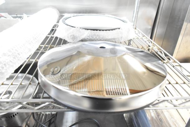 Brand new Lancaster Table & Seating stanchion base, shiny silver finish, scratch and dent condition, on metal shelf.