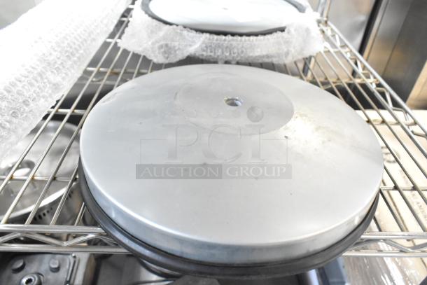 Brand new scratch and dent Lancaster Table & Seating stanchion in metal finish, with visible minor surface imperfections, on a shelf.