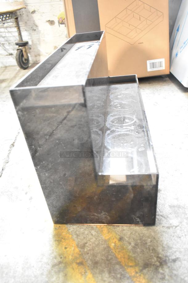 Auction item featuring a dark acrylic tiered lid dispenser, slightly worn. Includes box with organizer diagram.