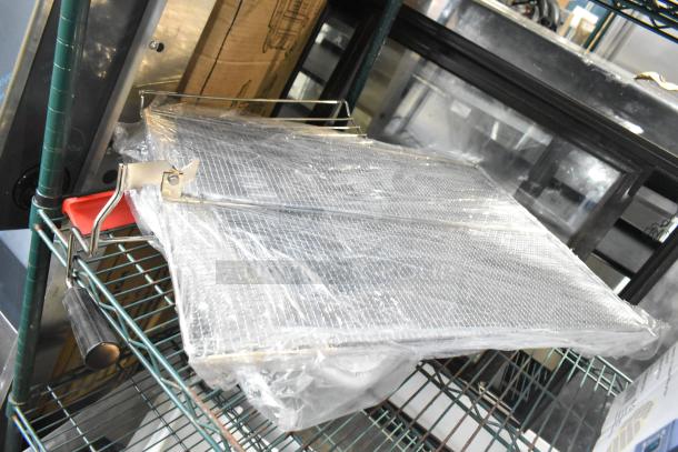 4 brand new Carlisle Sparta 24" red squeegees with plastic frames, still wrapped, on metal rack.