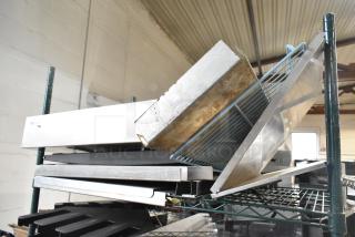 Tiered lot with various metal pieces and a blue poly rack, showing signs of use. Includes shelving units and trays.