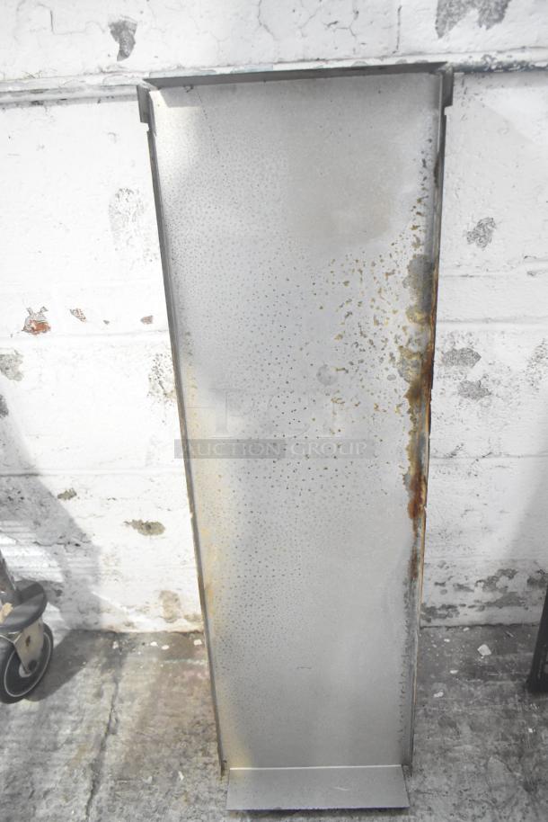Metal shelf panel with rust spots, part of auction tier lot; shows use and age with patina and surface wear.