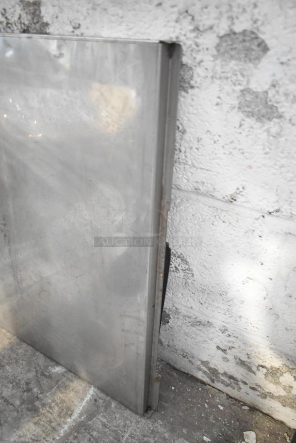 Metal sheet from tier lot, reflective surface with visible wear, part of assorted metal pieces and blue poly rack set.