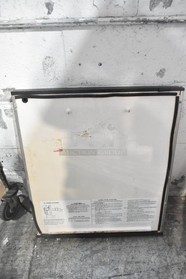 Auction item: mixed lot with metal pieces, blue poly rack. Includes a white metal panel with cleaning instructions, signs of wear.