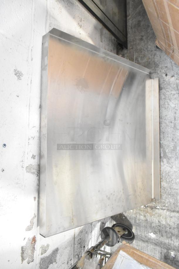 Metal sheet leaning against a wall, part of a mixed lot including blue poly rack, various metal pieces. Visible wear.