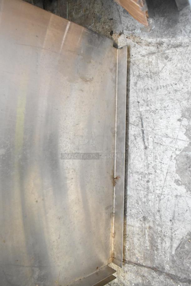 Various metal pieces with visible scratches and wear. Part of a tier lot including metal items and blue poly rack.