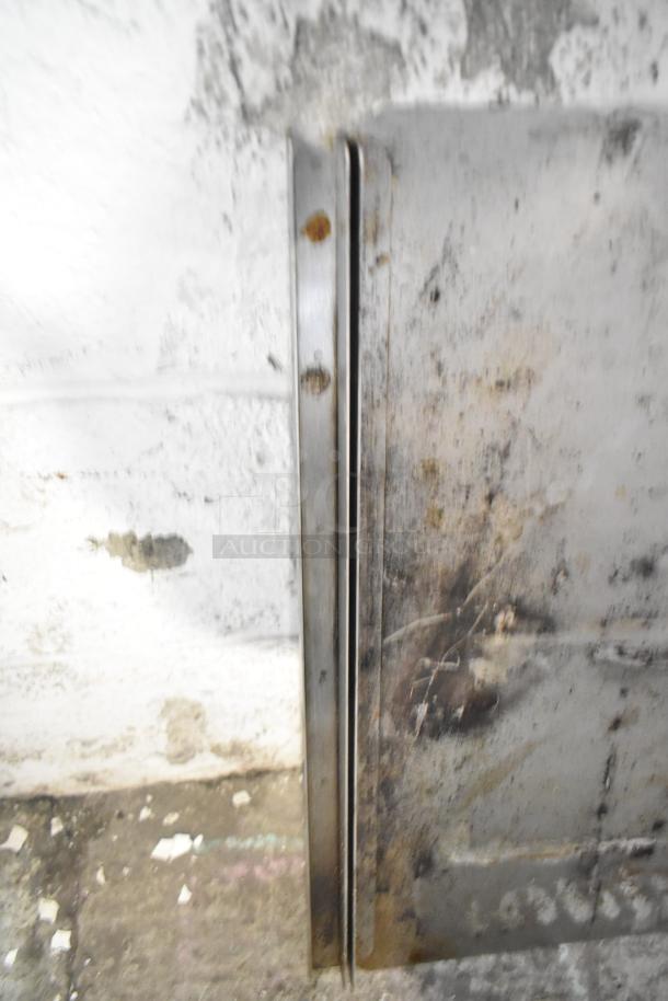 Alt text: Metal sheet with visible rust and wear in industrial setting. Part of auction lot including metal pieces and blue poly rack.