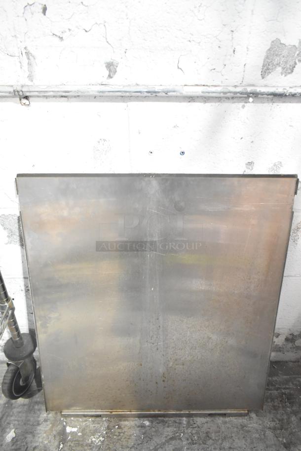 Auction lot with metal panel, showing signs of wear, alongside a blue poly rack. Appears used with visible scuff marks.