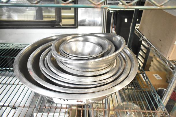 Stack of 25 various metal bowls in good condition on a metal shelf, labeled "141."