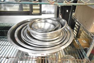 Stack of 25 various metal bowls in good condition on a metal shelf, labeled "141."