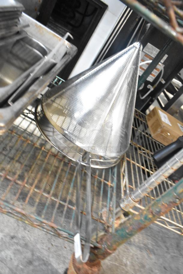 Tier lot of various kitchen items including a conical strainer and drop-in bins on a metal shelf. Items appear used.