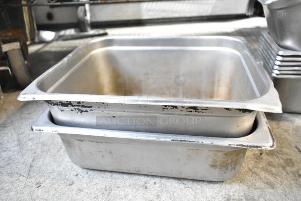 Metal drop-in bins with visible wear, stacked on a concrete floor. Part of a tier lot including a beverage dispenser.