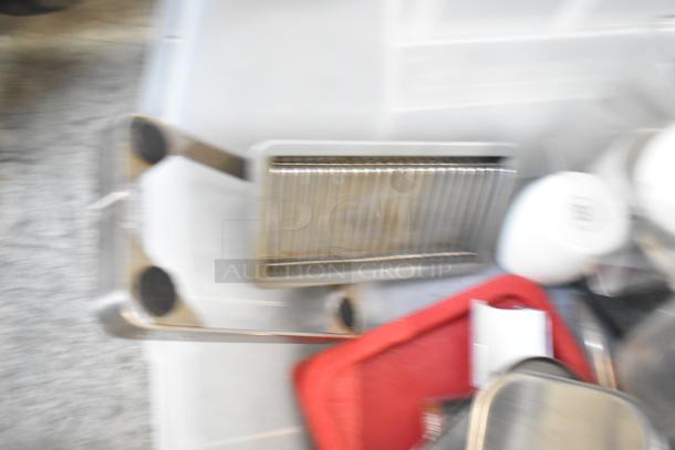 Blurry image of a mixed lot with a beverage dispenser, drop-in bins, and various items; condition unclear.