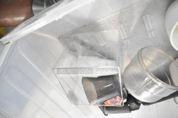 A mixed lot of items including transparent drop-in bins, stackable cups, and a beverage dispenser, all in good condition.
