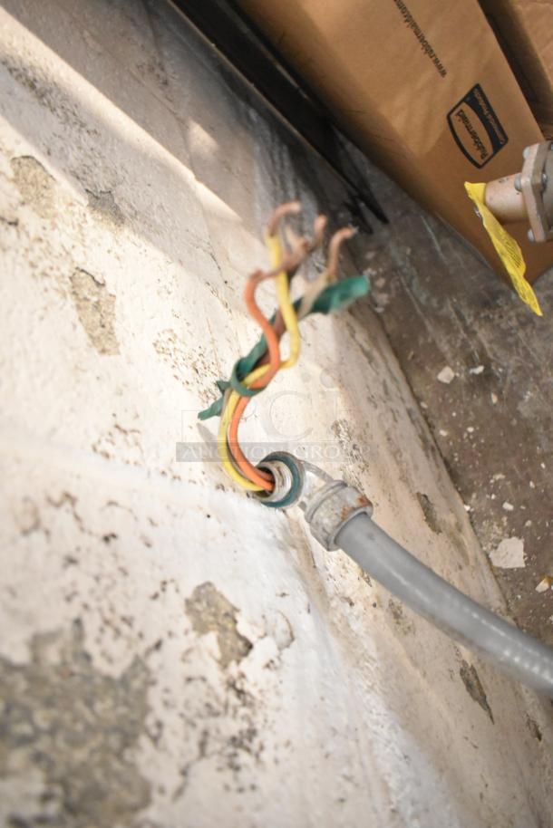 Wall wiring setup, not Hatco C-15 water heater. Shows exposed wires and conduit with a worn textured surface.