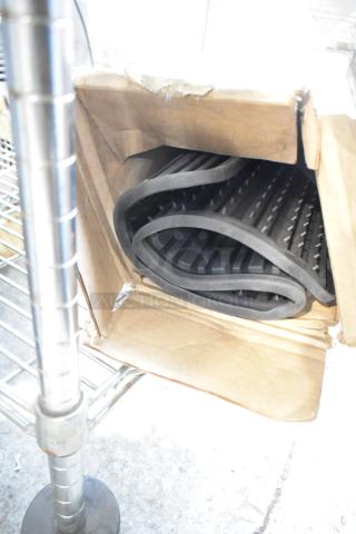 Black anti-fatigue floor mat, new condition, visible scratch and dent, rolled in cardboard box.