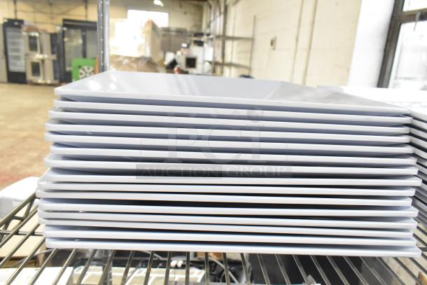 Stack of white plates on metal rack, new condition, part of 31-item auction including Ironcat gloves.