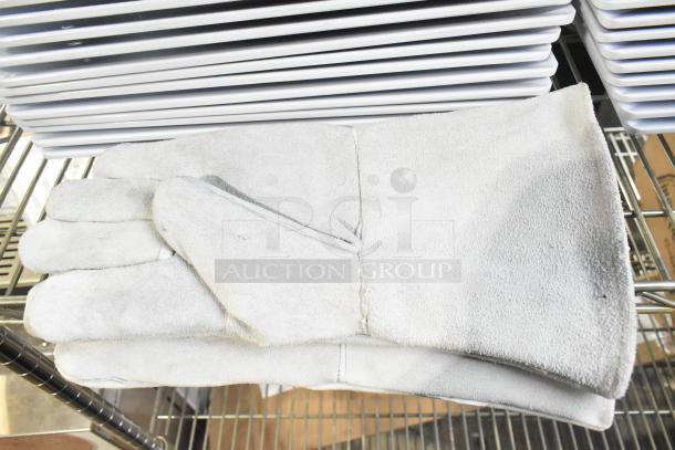 Gray Ironcat gloves on a metal shelf with stacked white plates above, auction bundle.