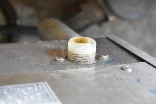 Bunn IMIX-5 commercial cappuccino machine top view. Visible connector and screws on metal surface. Some wear noted.