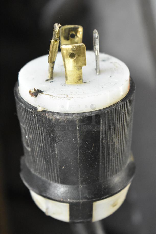 Close-up of a plug for a Bunn IMIX-5 Cappuccino Machine, showing three prongs. Plug appears in used condition.