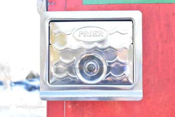 Chrome Prier water faucet access panel on red exterior wall of 2021 Titanium Cargo mobile kitchen trailer.