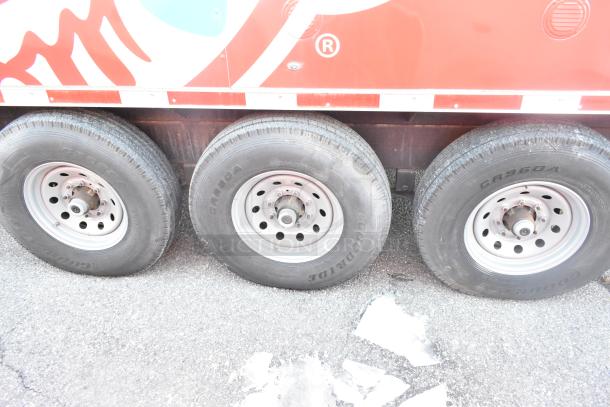 Triple axle detail of 2021 Titanium Cargo 8.5' x 28' mobile kitchen trailer, showcasing Goodyear tires.