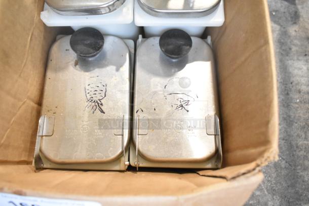 Cardboard box containing metal topping dispensers with black knobs, featuring engraved NSF logos and markings.