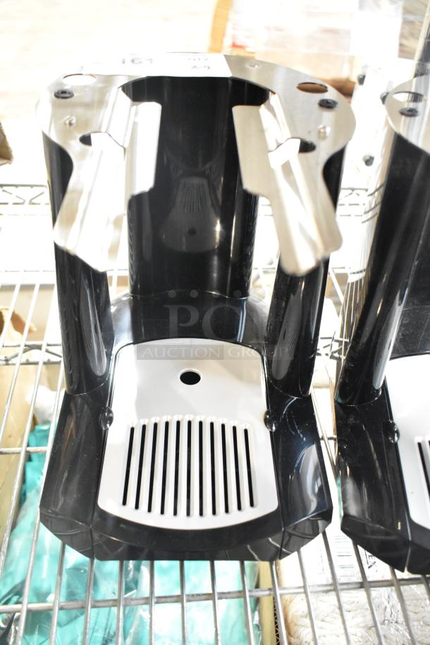 Two black beverage dispenser bases with stainless steel accents, shown in unused condition on a metal shelf.