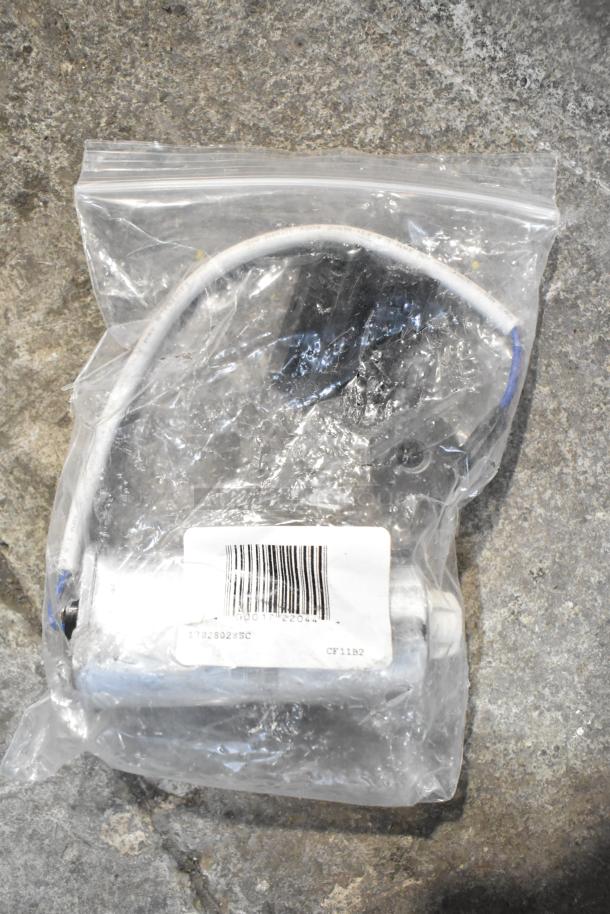 Plastic bag containing various parts including a start relay, plastic fitting, and parts bag. Label reads "17828028SC".