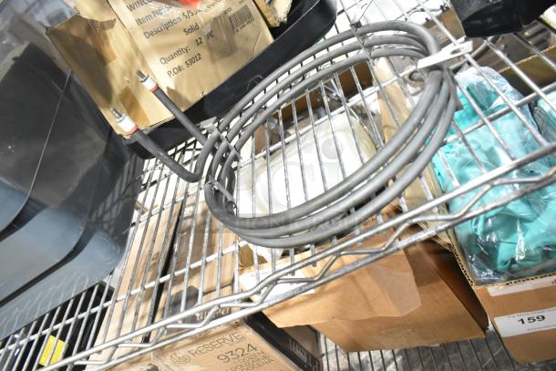 Four various items on a metal shelf, including a coiled gray cable, cardboard boxes, and bags with green contents. Some boxes labeled "Winco" and feature product information. Items appear new and in original packaging.