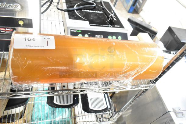 Roll of 500mm RMF-1M plastic wrap, partially wrapped, on a shelf with a label showing "164 QTY 1" from PCIAuctions.com.