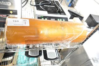 Roll of 500mm RMF-1M plastic wrap, partially wrapped, on a shelf with a label showing "164 QTY 1" from PCIAuctions.com.