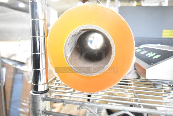 Roll of 500mm RMF-1M plastic wrap, new condition, visible inner core, on metal rack.