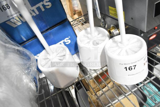 Four brushes including three toilet brushes with white bristles and handles, new condition. Labels show auction lot 167.