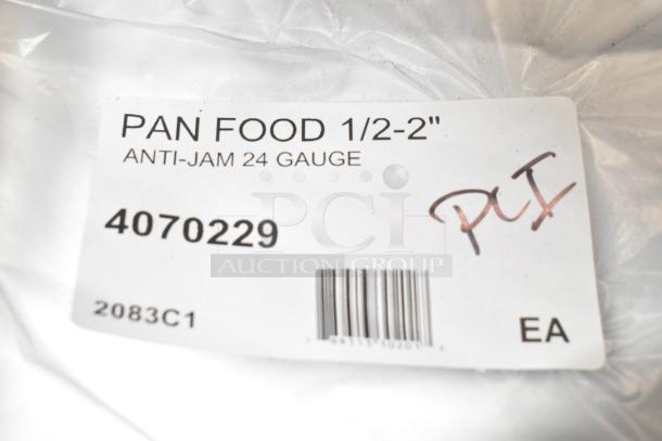Label on a stainless steel pan, indicating "PAN FOOD 1/2-2", Anti-Jam 24 Gauge", with code 4070229 and handwritten "PI".