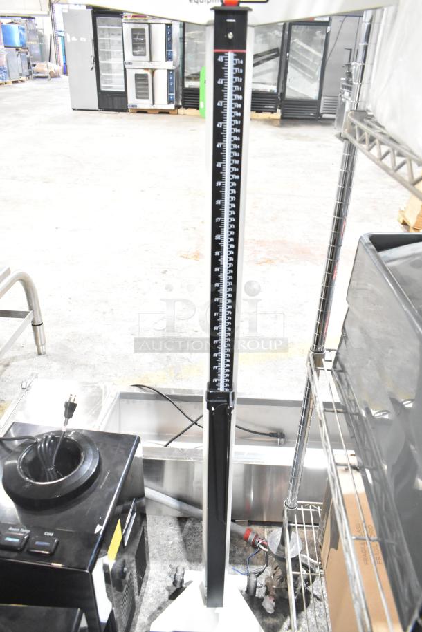 Galaxy floor-style scale with height rod in industrial setting. Black and white design, sturdy construction, good condition.