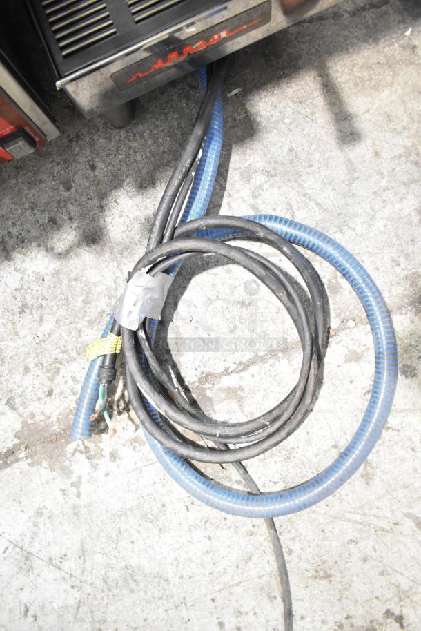 La Marzocco 2 group espresso machine wiring, countertop model with steam wands and portafilters, visible cords.