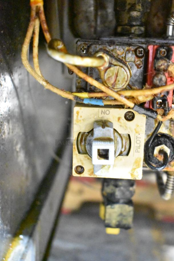 Close-up of the control panel of a Pitco Frialator SG14-S commercial fryer, showing wiring and a marked pilot switch.