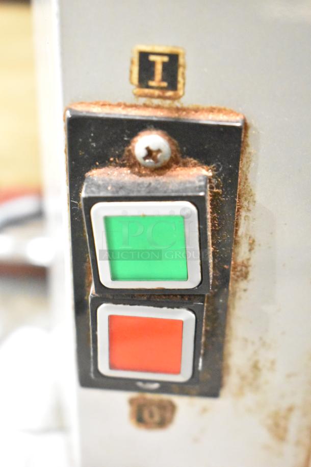 Mahlkonig K32S10 coffee grinder controls with green and red buttons; visible wear and corrosion around buttons.