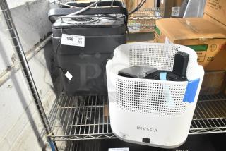 2 various fans, including Vissani and black model. Auction tag reads "199 x2." Located on metal shelf, fair condition.