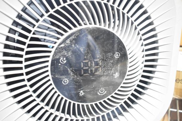 Two fans including a Midea model; digital control panel visible, showing signs of use, features adjustable settings.