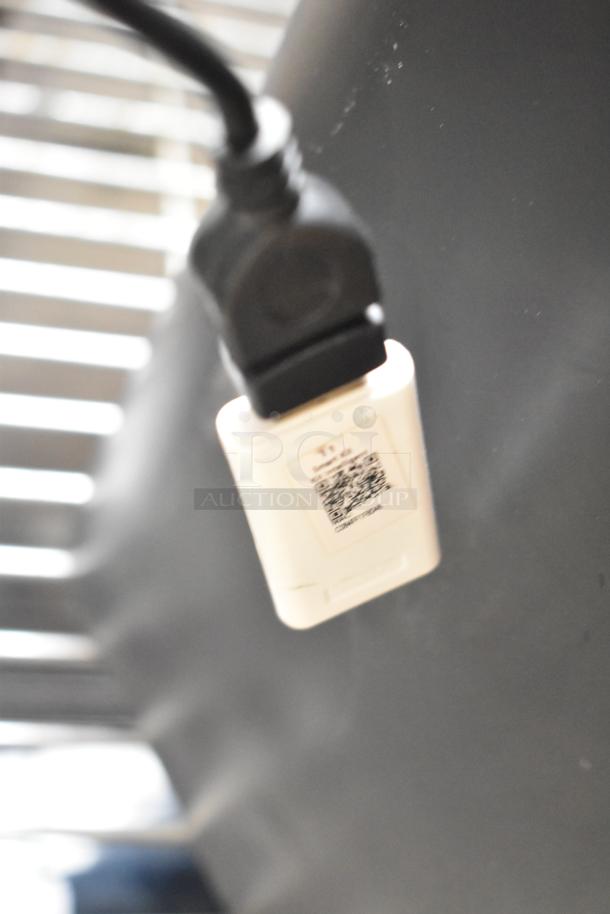 Close-up of a fan power cord with a QR code tag, part of a lot including Midea fan, auctioned as "2 Times Your Bid!".