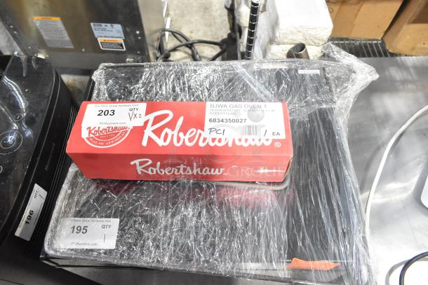 Brand new Robertshaw 4350-027 gas oven thermostat kit and Cooking Performance Group heating element, both in original packaging.