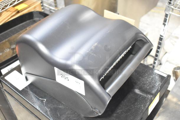 Brand new Bio-Kleen Poly wall-mounted paper towel dispenser, black, minor scratches visible, labeled "205 QTY."