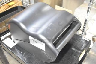 Brand new Bio-Kleen Poly wall-mounted paper towel dispenser, black, minor scratches visible, labeled "205 QTY."